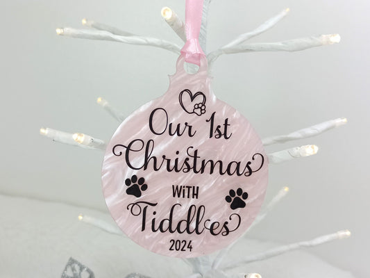 Decorative ornament with 'Our 1st Christmas with Cat or Dog' personalised text on a pink background, hanging against a white Christmas tree.